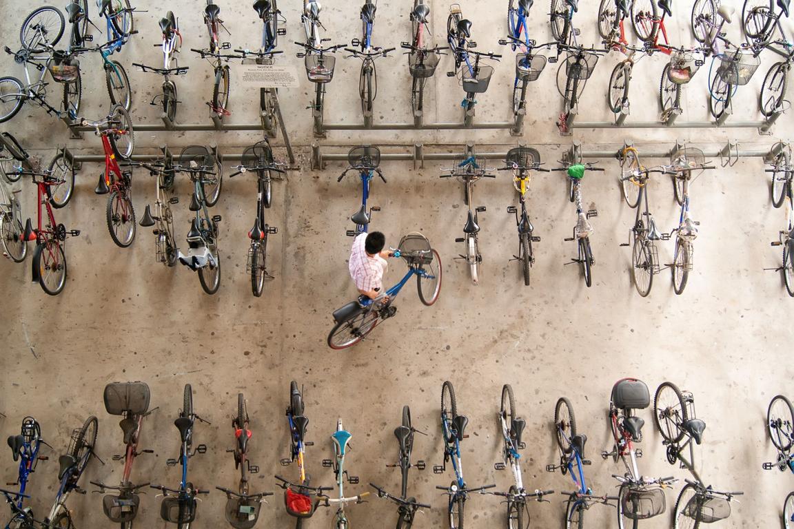 man putting bicycle up aerial view man putting bicycle up aerial view