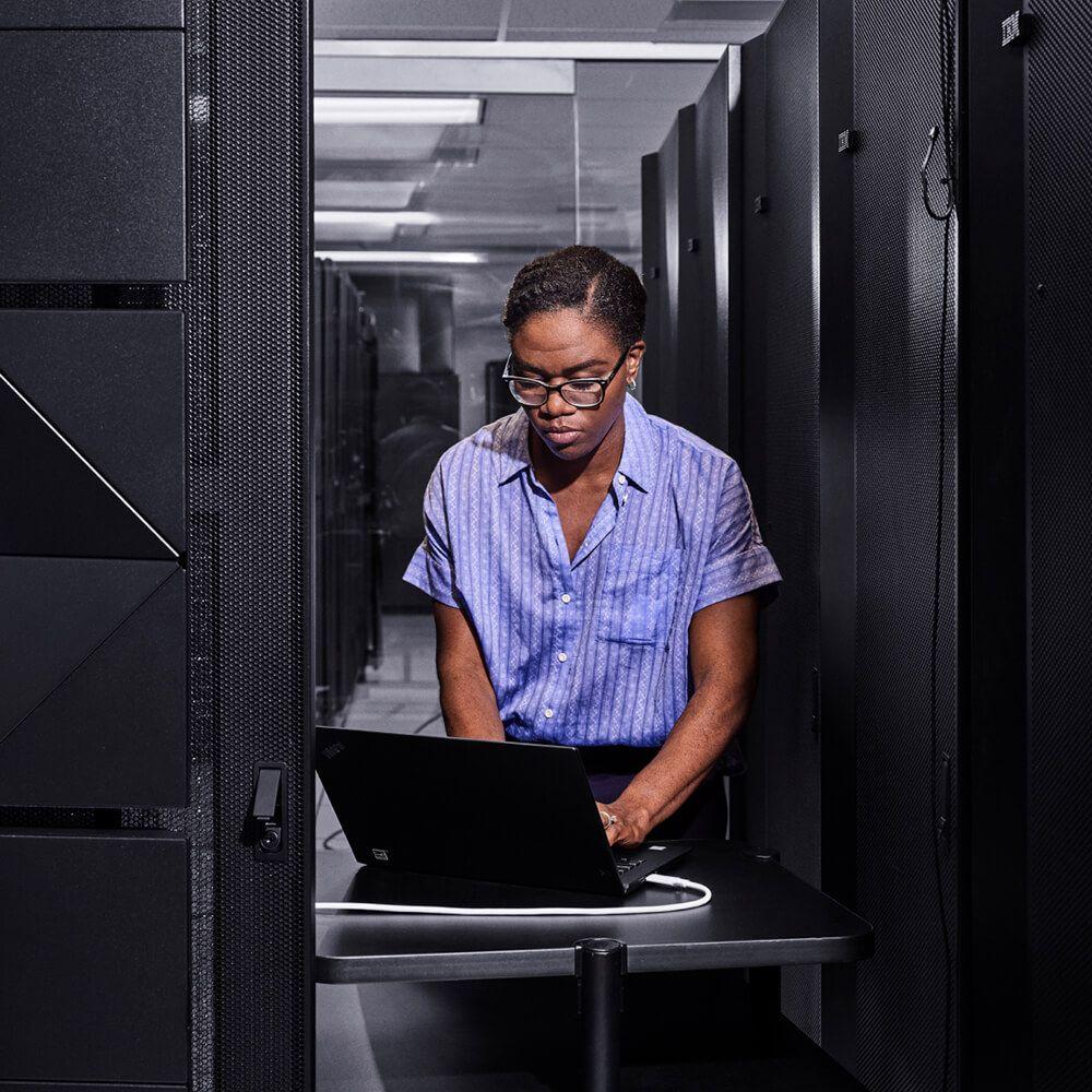 portait of person in server room at laptop portait of person in server room at laptop