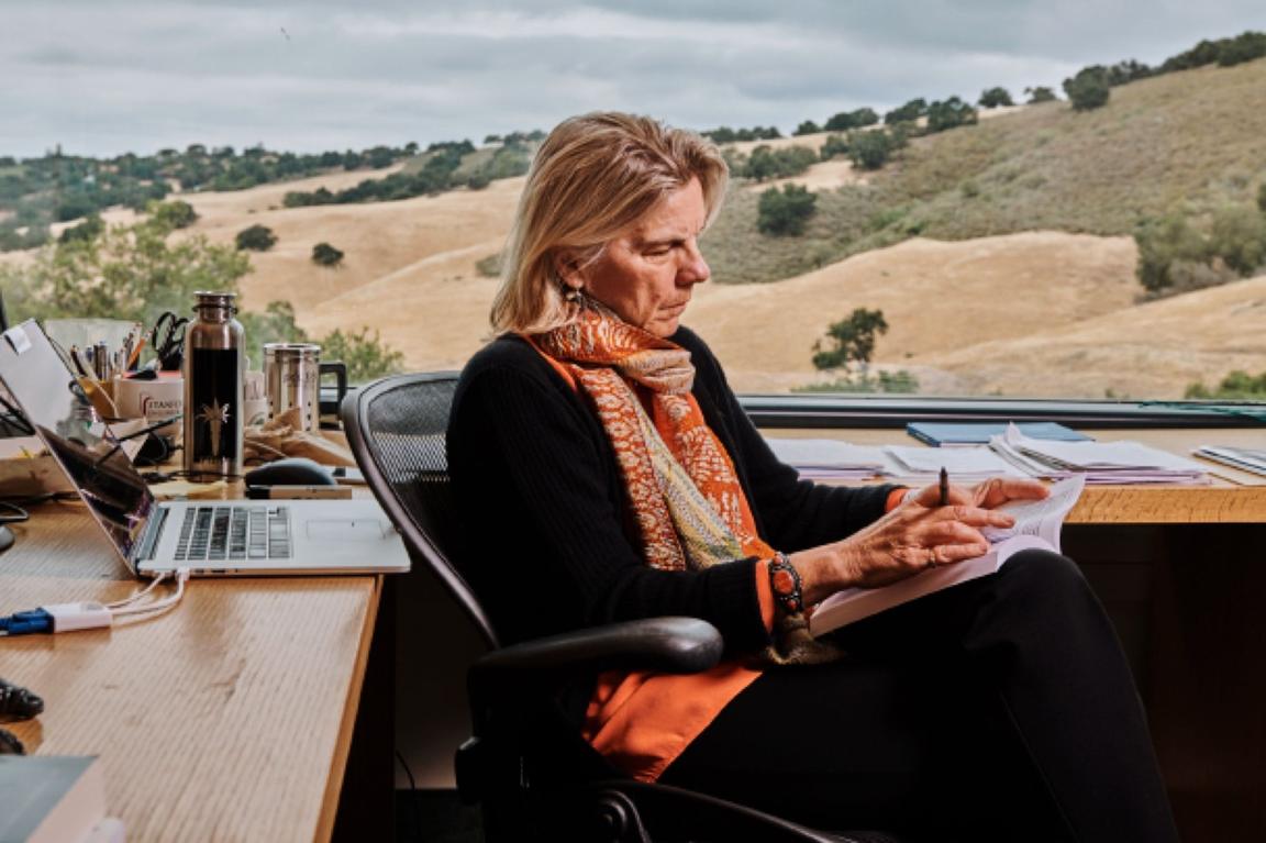 person working at desk with open field out window person working at desk with open field out window